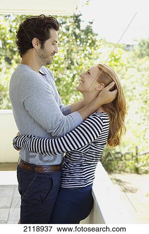 A Man And Woman On A Balcony In An Embrace With His Hands In Her Hair; Wailua Kauai Hawaii United States Of America View Large Photo Image Stock Photo - A Man And Woman On A Balcony In An Embrace With His Hands In Her Hair; Wailua Kauai Hawaii United States Of America. Fotosearch