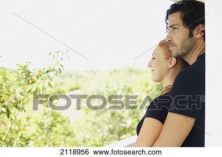 Stock Photograph - A Man And Woman Standing Close Together On A Balcony; Wailua Kauai Hawaii United States Of America. Fotosearch