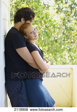 Stock Photo - A Man And Woman Standing In An Embrace On A Balcony; Wailua Kauai Hawaii United States Of America. Fotosearch