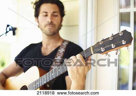 A Man Playing His Guitar Outside His House; Wailua Kauai Hawaii United States Of America View Large Photo Image Stock Photo - A Man Playing His Guitar Outside His House; Wailua Kauai Hawaii United States Of America. Fotosearch