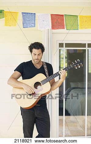 Stock Image - A Man Playing His Guitar; Wailua Kauai Hawaii United States Of America. Fotosearch