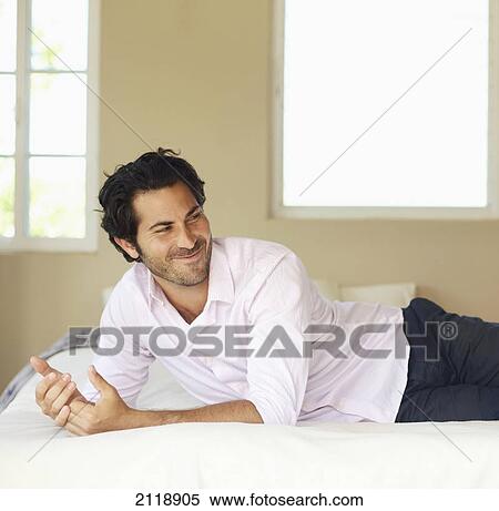 A Man Relaxing On A Bed While Laughing; Wailua Kauai Hawaii United States Of America View Large Photo Image Stock Photography - A Man Relaxing On A Bed While Laughing; Wailua Kauai Hawaii United States Of America. Fotosearch