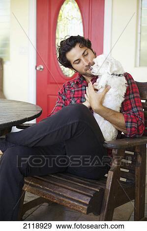 A Man Sits On A Wooden Chair On A Patio With His Dog; Wailua Kauai Hawaii United States Of America View Large Photo Image Stock Photo - A Man Sits On A Wooden Chair On A Patio With His Dog; Wailua Kauai Hawaii United States Of America. Fotosearch