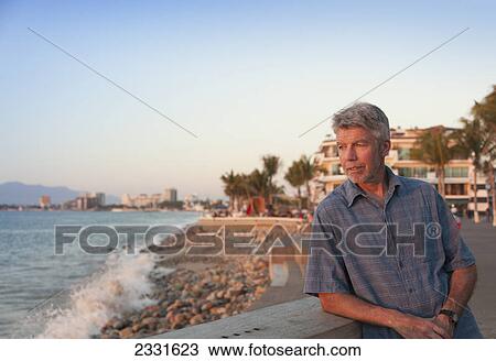 A man stands on the malecon as the sun sets; Puerto vallarta mexico View Large Photo Image Stock Image - A man stands on the malecon as the sun sets; Puerto vallarta mexico. Fotosearch