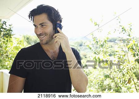 A Man Talks On The Phone While Standing On A Balcony; Wailua Kauai Hawaii United States Of America View Large Photo Image Stock Photograph - A Man Talks On The Phone While Standing On A Balcony; Wailua Kauai Hawaii United States Of America. Fotosearch