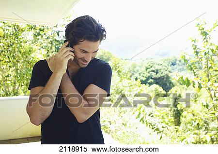 A Man Talks On The Phone While Standing On A Balcony; Wailua Kauai Hawaii United States Of America View Large Photo Image Stock Photography - A Man Talks On The Phone While Standing On A Balcony; Wailua Kauai Hawaii United States Of America. Fotosearch