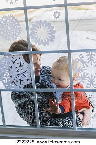 A mother and young son standing at the front window of their house with snowflakes on it; Willimantic connecticut united states of america View Large Photo Image Stock Photo - A mother and young son standing at the front window of their house with snowflakes on it; Willimantic connecticut united states of america. Fotosearch