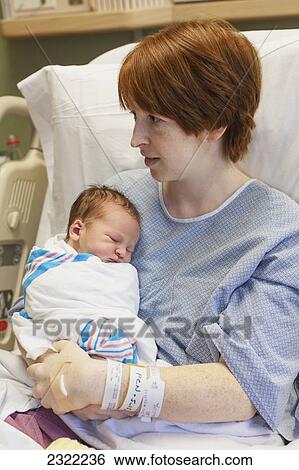 Stock Photograph - A mother holds her newborn baby in a hospital bed; Willimantic connecticut united states of america. Fotosearch