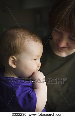 A mother looks at her baby boy as his face is illuminated by the sunlight from a window; Willimantic connecticut united states of america View Large Photo Image Stock Image - A mother looks at her baby boy as his face is illuminated by the sunlight from a window; Willimantic connecticut united states of america. Fotosearch