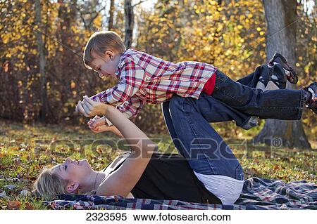 A mother playing with her young son in a park in autumn; Edmonton alberta canada View Large Photo Image Stock Photography - A mother playing with her young son in a park in autumn; Edmonton alberta canada. Fotosearch