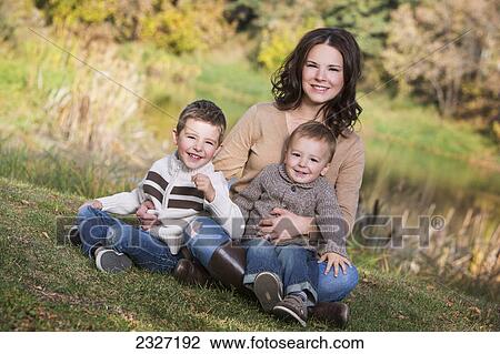 Stock Image - A mother with her two young sons in a park in autumn; St. albert alberta canada. Fotosearch