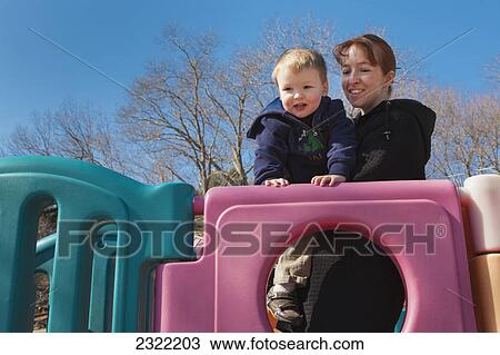 Stock Image - A mother with her young son at the playground; Willimantic connecticut united states of america. Fotosearch