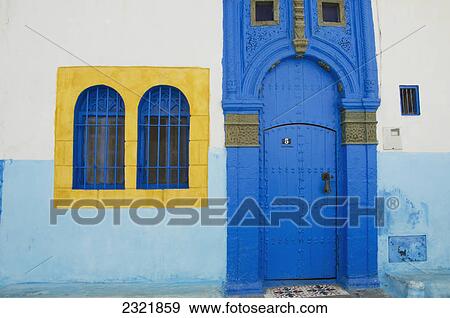 Stock Photo - A Painted Blue Door And Bright Yellow Window Frame On A House In Old Town; Rabat Morocco. Fotosearch