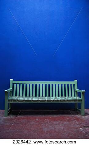 Stock Image - A painted green bench along a blue wall; Marrakech morocco. Fotosearch