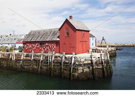 Stock Image - A red building on a pier at the water's edge; Rockport massachusetts united states of america. Fotosearch