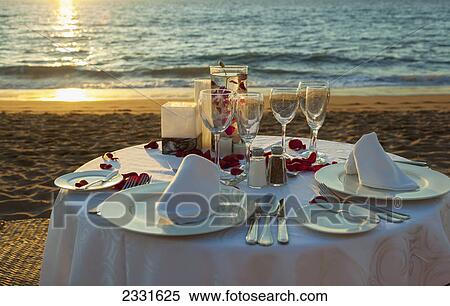 A romantic dinner for two complete with rose petals orchids and a setting sun on the beach; Puerto vallarta mexico View Large Photo Image Stock Photography - A romantic dinner for two complete with rose petals orchids and a setting sun on the beach; Puerto vallarta mexico. Fotosearch