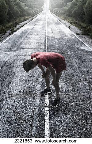 A Runner Stops To Take A Break On A Wet Road; Tarifa Cadiz Andalusia Spain View Large Photo Image Stock Image - A Runner Stops To Take A Break On A Wet Road; Tarifa Cadiz Andalusia Spain. Fotosearch