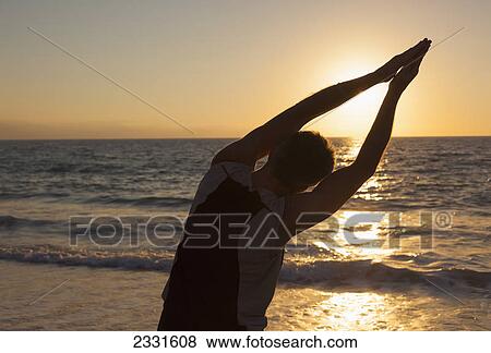A senior man does yoga on the beach as the sun sets; Puerto vallarta mexico View Large Photo Image Stock Photo - A senior man does yoga on the beach as the sun sets; Puerto vallarta mexico. Fotosearch