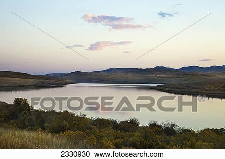 Stock Image - A tranquil lake at sunset; Alberta canada. Fotosearch