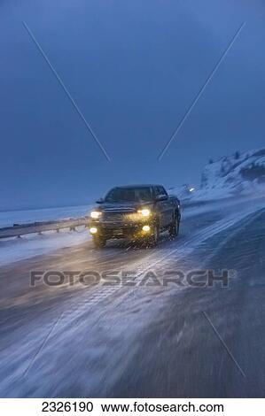 A truck driving on the seward highway during a snowstorm at twilight in winter beluga point; Anchorage alaska united states of america View Large Photo Image Stock Image - A truck driving on the seward highway during a snowstorm at twilight in winter beluga point; Anchorage alaska united states of america. Fotosearch