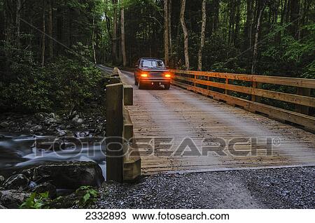 Stock Image - A vehicle going over a river on a wooden bridge in great smoky mountains national park; Tennessee united states of america. Fotosearch