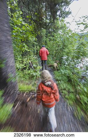 Stock Photo - A woman and daughter walking along a path next to the shore of byers lake in campground denali state park; Alaska united states of america. Fotosearch