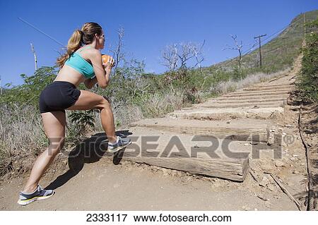 Stock Photo - A woman exercises with a weighted ball; Honolulu oahu hawaii united states of america. Fotosearch