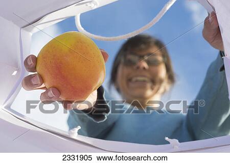 A woman pulling a piece of fruit from a shopping bag; Locarno ticino switzerland View Large Photo Image Stock Photography - A woman pulling a piece of fruit from a shopping bag; Locarno ticino switzerland. Fotosearch