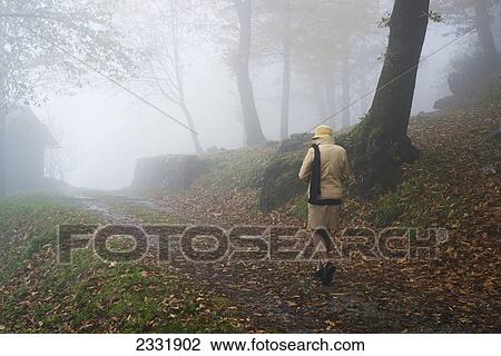 A woman walking down a foggy path in autumn; Bellinzona ticino switzerland View Large Photo Image Stock Image - A woman walking down a foggy path in autumn; Bellinzona ticino switzerland. Fotosearch