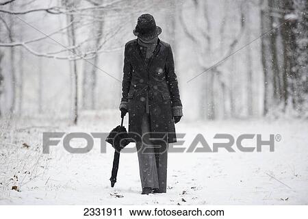 A woman walking down a snowy path in winter; Locarno ticino switzerland View Large Photo Image Stock Image - A woman walking down a snowy path in winter; Locarno ticino switzerland. Fotosearch