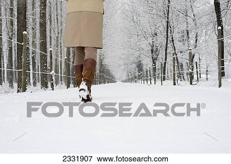 A woman walks down a snowy path in winter; Locarno ticino switzerland View Large Photo Image Stock Photo - A woman walks down a snowy path in winter; Locarno ticino switzerland. Fotosearch