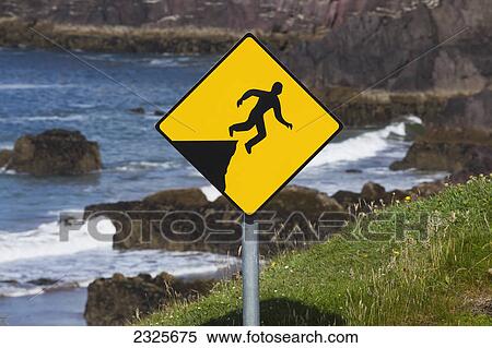 A yellow warning sign depicting a person falling off a cliff; County kerry ireland View Large Photo Image Stock Photography - A yellow warning sign depicting a person falling off a cliff; County kerry ireland. Fotosearch