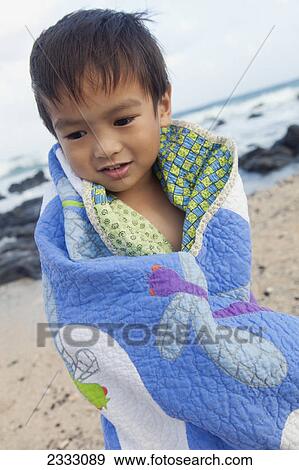A young boy wrapped in a blanket at the beach; Honolulu oahu hawaii united states of america View Large Photo Image Stock Photo - A young boy wrapped in a blanket at the beach; Honolulu oahu hawaii united states of america. Fotosearch