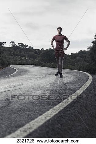 A Young Man In Running Shorts And T-Shirt Posing On A Road; Tarifa Cadiz Andalusia Spain View Large Photo Image Stock Photograph - A Young Man In Running Shorts And T-Shirt Posing On A Road; Tarifa Cadiz Andalusia Spain. Fotosearch