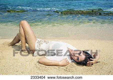 A young woman modelling and laying on the beach; Kauai hawaii united states of america View Large Photo Image Picture - A young woman modelling and laying on the beach; Kauai hawaii united states of america. Fotosearch