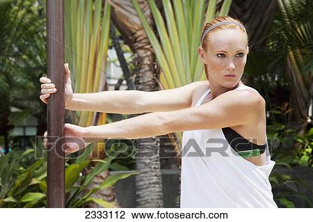 A young woman stretches on a pole; Honolulu oahu hawaii united states of america View Large Photo Image Stock Image - A young woman stretches on a pole; Honolulu oahu hawaii united states of america. Fotosearch