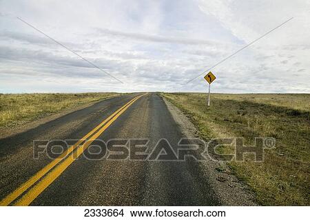 An empty highway with a sign indicating a curve up ahead; Saskatchewan, Canada View Large Photo Image Picture - An empty highway with a sign indicating a curve up ahead; Saskatchewan, Canada. Fotosearch