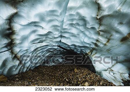 Stock Image - An ice cave with a scalloped ice ceiling and a floor of glacial till; Jasper national park. Fotosearch