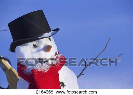 Stock Photography - Closeup Of Snowman W/Black Top Hat & Red Scarf Interior Alaska Winter. Fotosearch