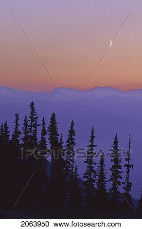Stock Image - Crescent Moon Rises In Sunset Over Mountains, Whistler, Bc Canada. Fotosearch