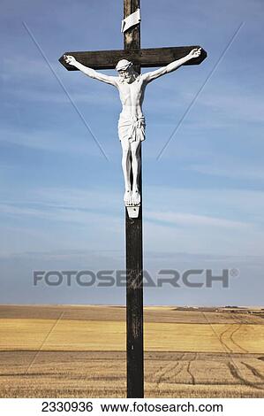 Stock Photograph - Crucifix and a farm field in the background; Saskatchewan canada. Fotosearch