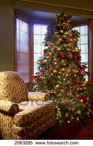 Stock Photography - Decorated Christmas Tree Nestled By The Window Next To An Armchair, Canada, Ontario. Fotosearch