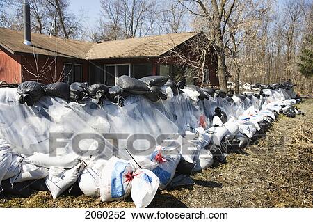 Stock Image - Dyke Of Sandbags Around Rural Home To Protect From Red River Floodwaters, Rural Manitoba. Fotosearch