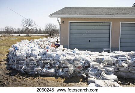 Stock Photography - Dyke Of Sandbags Around Rural Home To Protect From Red River Floodwaters, Rural Manitoba. Fotosearch