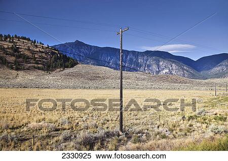 Electrical wires going across a field with mountains in the background; British columbia canada View Large Photo Image Stock Photography - Electrical wires going across a field with mountains in the background; British columbia canada. Fotosearch