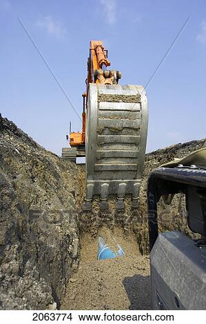 Excavator Filling In Section Of Drainage Pipe With Dirt; Canada, Ontario, Hamilton (Composting Facility) View Large Photo Image Picture - Excavator Filling In Section Of Drainage Pipe With Dirt; Canada, Ontario, Hamilton (Composting Facility). Fotosearch