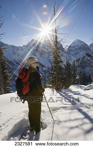 Female snowshoer in the mountains with snow covered mountains in the background; Lake louise alberta canada View Large Photo Image Stock Image - Female snowshoer in the mountains with snow covered mountains in the background; Lake louise alberta canada. Fotosearch