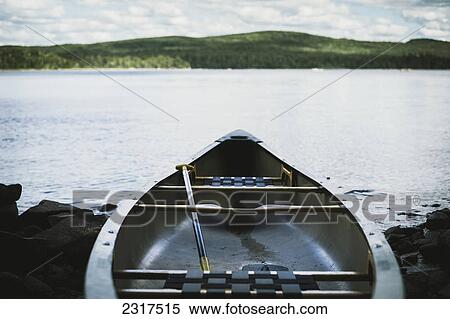 Fiberglass Canoe At Lakeside With Mountain On The Horizon; Thetford Mines Quebec Canada View Large Photo Image Stock Photography - Fiberglass Canoe At Lakeside With Mountain On The Horizon; Thetford Mines Quebec Canada. Fotosearch