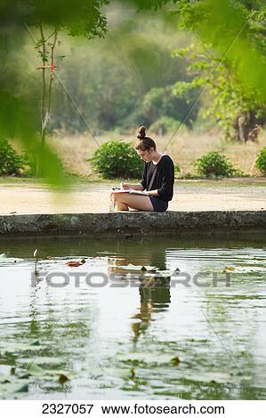 Girl painting beside a lake; Chiang mai thailand View Large Photo Image Stock Photo - Girl painting beside a lake; Chiang mai thailand. Fotosearch