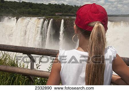 Stock Image - Girl watching iguazu falls from outlook point; Argentina. Fotosearch